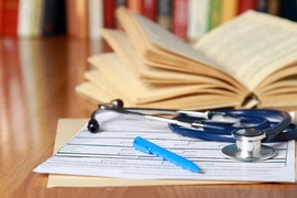 An image of a book, prescription and pen lying on the desk